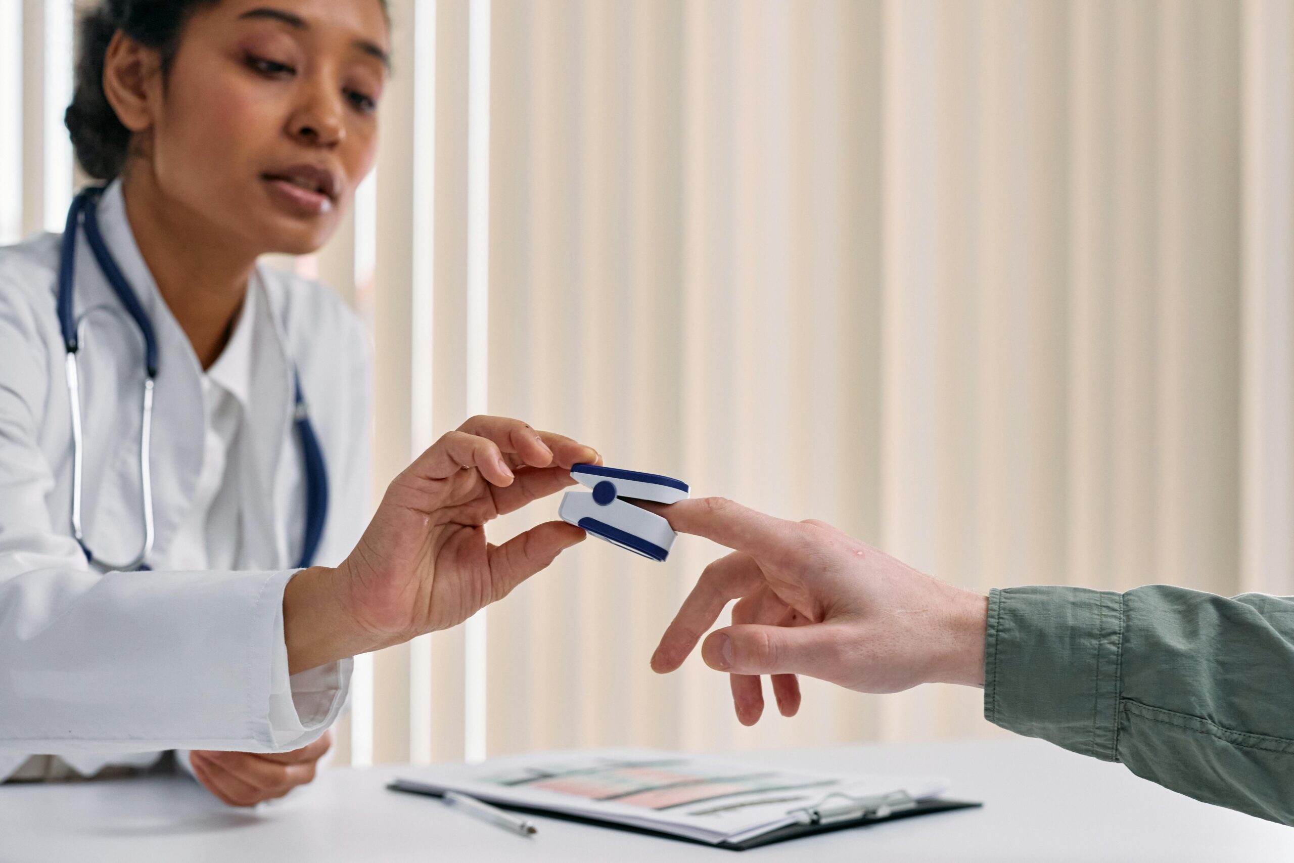 doctor putting a heartbeat monitor on a patient's finger